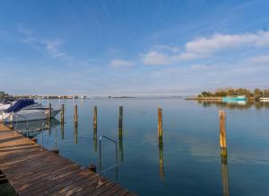un quai avec un bateau dans l'eau dans l'établissement Casa di Annika - Vista Laguna e Parcheggio privato, à Grado