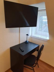 een zwart bureau met een lamp en een stoel bij Gasthaus Neue Mühle in Kassel