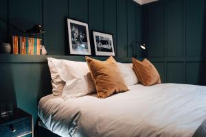 sypialnia z łóżkiem z poduszkami w obiekcie The George w mieście Cheltenham