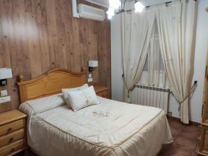 1 dormitorio con 1 cama con sábanas blancas y ventana en Casa Rural IRIS, en Villanueva de los Infantes