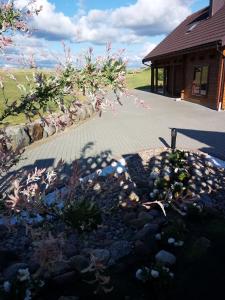 un jardin avec des fleurs et des rochers devant un bâtiment dans l'établissement Relax House, à Varkaliai