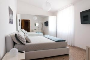 een witte slaapkamer met een bed en een spiegel bij Fly by Suites Pescara in Pescara