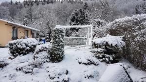 einen schneebedeckten Hof mit einem Tor und Bäumen in der Unterkunft Ferienwohnung Schortestraße in Ilmenau