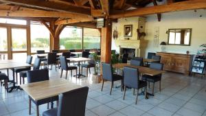 a restaurant with tables and chairs and a fireplace at Hôtel Le Mas del Pechs - Chambres avec terrasse in Sarlat-la-Canéda