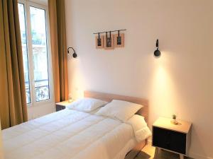1 dormitorio con cama blanca y ventana en Hypercentre/Lamartine Appartement-306, en Niza