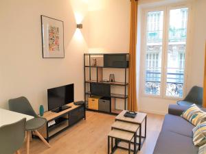 sala de estar con sofá azul y TV en Hypercentre/Lamartine Appartement-306, en Niza
