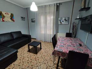ein Wohnzimmer mit Sofa und Tisch in der Unterkunft Apartamentos Avenida de la paz 2 in Logroño