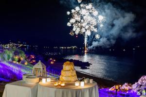 a table with a wedding cake on it with fireworks at Hotel Sporting in Porto Rotondo