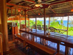 Las Caletas Lodge في دريك: مطعم بطاولات وكراسي خشبية وإطلالة على المحيط
