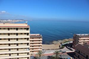 uma vista para um edifício e para o oceano em Przytulny Apartament z widokiem na morze !!!!! em La Mata
