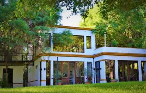a white house with glass doors and trees at Posada del Olivo in Nonogasta