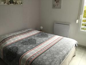 Dormitorio pequeño con cama con edredón blanco y negro en L Édelweiss et sa piscine en Albertville