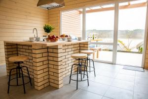 a kitchen with a brick wall and bar with stools at Шале Рутенія - Chalet Rutenia apartments in Neporotovo
