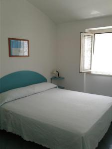 a bedroom with a large white bed with a window at Borgo Antico in Peschici