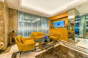 a living room with yellow chairs and a table at Elite Al Hamra - Al Andalus in Jeddah