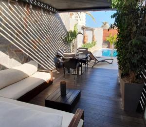 a patio with a couch and chairs and a table at Villa Adler Men Only in Playa del Ingles