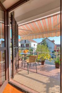 a patio with a table and a chair on a balcony at Branka Apartments in Tivat
