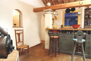 kuchnia z blatem i stołkami w pokoju w obiekcie La maison jaune w mieście La Roque-sur-Pernes