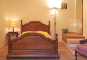 sypialnia z drewnianym łóżkiem w pokoju w obiekcie La maison jaune w mieście La Roque-sur-Pernes