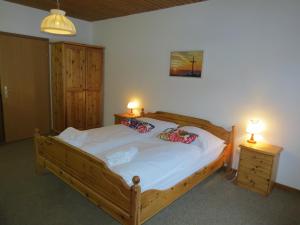 um quarto com uma grande cama de madeira e 2 candeeiros em Der Bodenbauer em Thörl