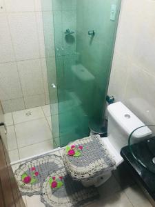 a bathroom with a toilet with a glass shower at Aconchego na Capital do Forró in Caruaru +8 photos