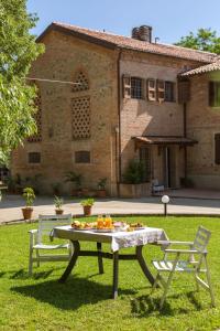 - une table de pique-nique et 2 chaises devant un bâtiment dans l'établissement Agriturismo Molino Nuovo, à Castel San Pietro Terme