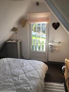 ein Schlafzimmer mit einem Bett, einem Waschbecken und einem Fenster in der Unterkunft Cocon sur mer in Varengeville-sur-Mer