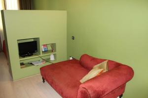 a living room with a red couch and a television at Apartaments Sant Jordi Girona 97 in Barcelona