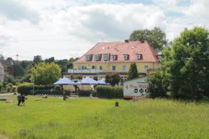 una grande casa gialla con tetto rosso in un campo di Gasthaus Neue Mühle a Kassel