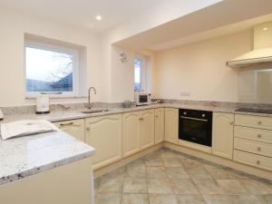 Una cocina grande con gabinetes blancos y una ventana. en Westholme, en Barnard Castle