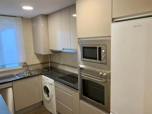 a kitchen with a microwave and a stove top oven at Apartment Lucena Park in Lucena