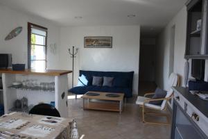 een woonkamer met een blauwe bank en een tafel bij Appartement au calme à Hendaye in Hendaye