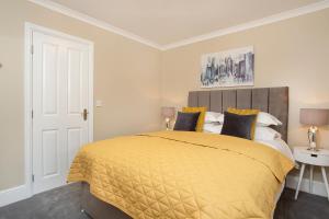 sypialnia z dużym łóżkiem z żółtą narzutą w obiekcie Knavesmire Mews 3 bedrooms-Free parking w mieście York