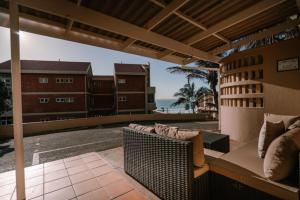 an outdoor patio with a couch and a view of the ocean at M8 Umdloti Holiday Resort in Umdloti