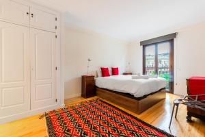 een witte slaapkamer met een bed en een rood tapijt bij Minty Stay 1BD -El Retiro in Madrid