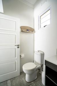 a white bathroom with a toilet and a window at M8 Umdloti Holiday Resort in Umdloti