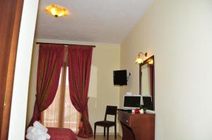 a bedroom with a bed and a desk and a mirror at Hotel Gogos in Kalabaka