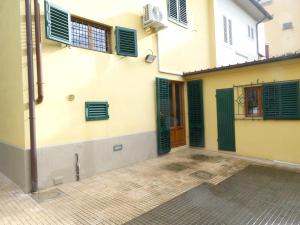 un edificio con ventanas con contraventanas verdes y un patio en Casa storica e confortevole, en Empoli