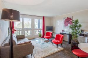 濱海圖維列的住宿－Charming and calm flat with balcony and parking in Trouville - Welkeys，客厅配有沙发和2把红色椅子