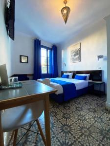 a bedroom with a bed and a table and a desk at Hôtel Central in Casablanca