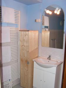 ein Bad mit einem Waschbecken und einem Spiegel in der Unterkunft Gîtes du Kreuzweg in Le Hohwald