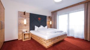 a bedroom with a large bed and a window at Panorama Appartements in Längenfeld