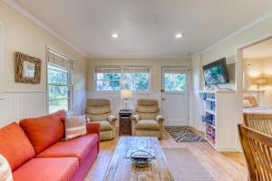 a living room with a red couch and a table at Woodland Cottage by the Sea in Yachats