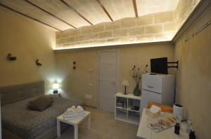 a small room with a bed and a refrigerator at Le dimore della Luna in Matera