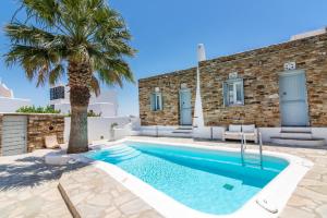 uma villa com uma piscina e uma palmeira em Onar Hotel & Suites em Tinos Town