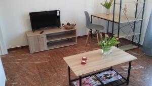 uma sala de estar com uma televisão e uma mesa em Central Location em Nafplio