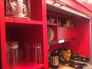 a red cabinet with dishes and glasses in it at Oneiro in Vathírrevma