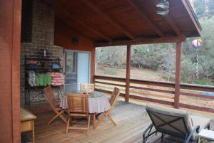a screened in porch with a table and chairs at Sunny Pines Cottage in Mariposa