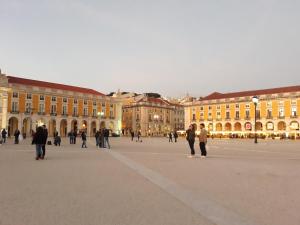 un grupo de personas caminando frente a un gran edificio en Ameli Rooms, en Lisboa