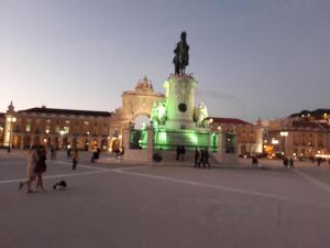 a plaza with a statue in front of a building at Ameli Rooms in Lisbon